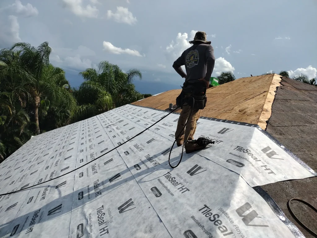 An Ace Pro Roofing contractor installing Westlake Royal TileSeal HT high-temperature underlayment on a residential roof deck in Palm Beach Gardens, Florida.