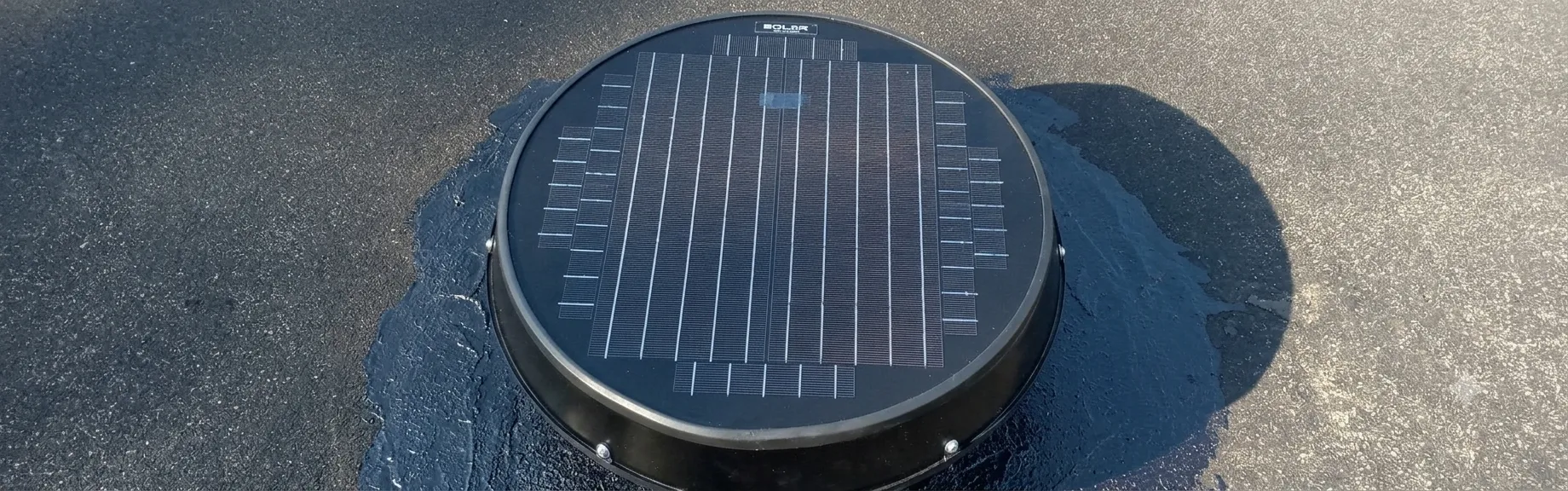 Solar-powered roof ventilation fan installed on a flat commercial roofing system